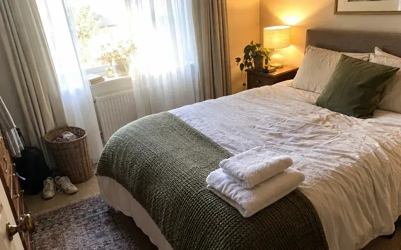 Tidy spare bedroom with folded towels on the bed ready for a guest