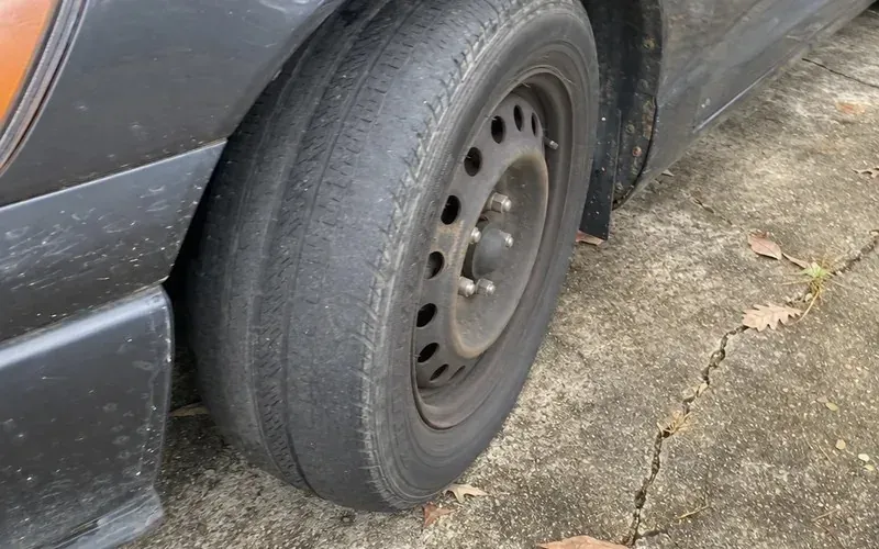 Worn car tire showing the wear that delivery miles add up to
